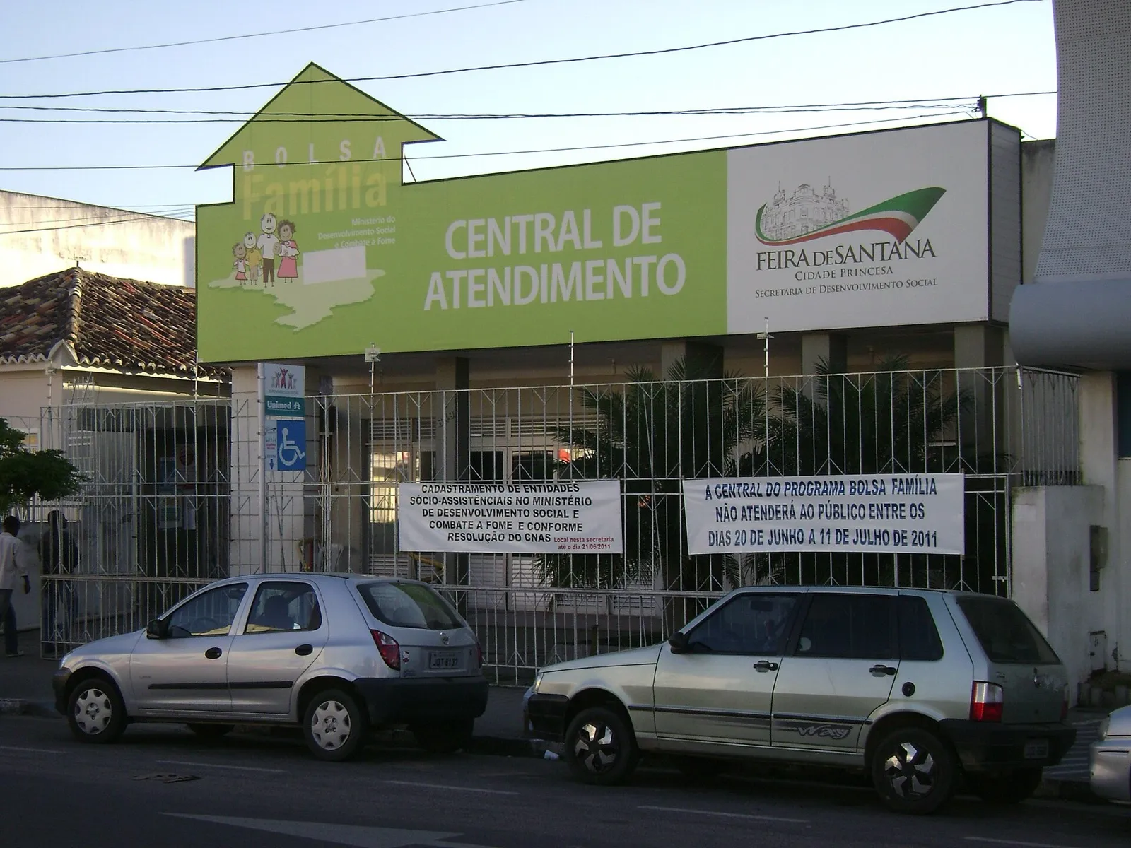 Fachada da Central de Atendimento do Bolsa Família em Feira de Santana, na Bahia, com a placa verde do programa.