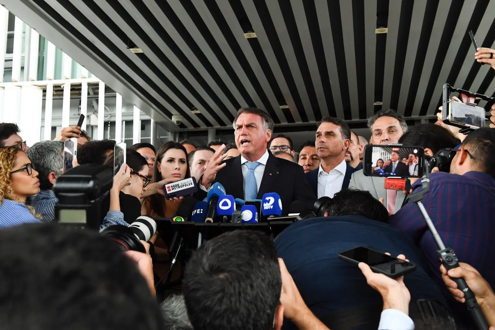 O ex-presidente Jair Bolsonaro fala à imprensa em entrevista coletiva, ao lado do senador Flávio Bolsonaro e de aliados do PL, em Brasília.