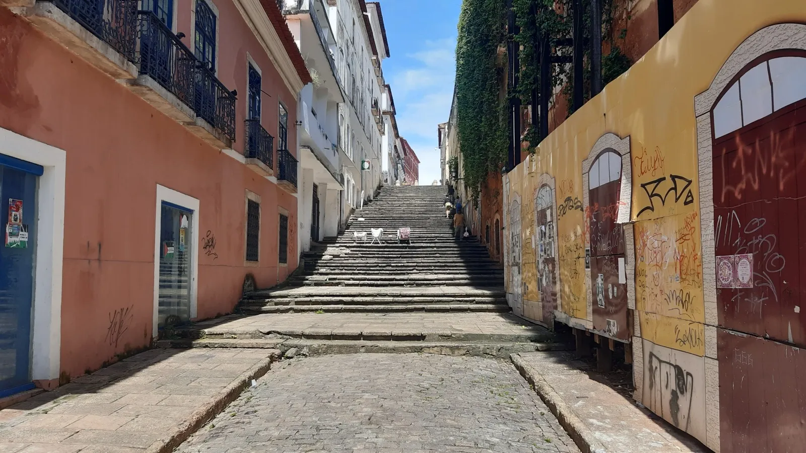 Escadaria de pedra entre casarios coloridos no centro histórico de São Luís, capital do Maranhão, sob céu azul.